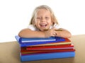 Cute little schoolgirl happy on desk leaning in relax on books Royalty Free Stock Photo