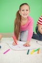 Cute little schoolgirl smiling at camera while drawing Royalty Free Stock Photo