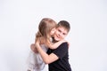 Cute little sister kissing hugging her handsome older brother teenager on white background Royalty Free Stock Photo