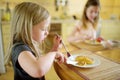 Cute little sisters enjoying their breakfast at home. Pretty children eating pancakes with strawberry sauce before school Royalty Free Stock Photo