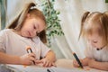 Cute little sisters are painting on table. Preschooler, 4 and 8 years child in living room. Small girl kids doing Royalty Free Stock Photo