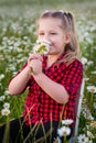 Cute little smiling girl in the chamomile