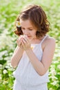 Cute little smiling girl on a chamomile field in spring. Enjoys the scent of daisies with his eyes closed Royalty Free Stock Photo