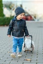 Cute little smiling girl in stylish clothes with pink suitcase in the airport. Kids travel. Royalty Free Stock Photo