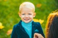 Cute little smiling happy boy in suit. Portrait of kid in spring park outdoors. Close-up face child playing outdoors in Royalty Free Stock Photo