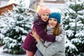 Cute little smiling kid girl and mother on christmas tree market. Happy child, daughter and young woman in winter Royalty Free Stock Photo