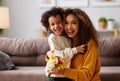 Cute little son giving flower bouquet his mom for Mothers day