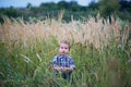 Cute little stands in the middle of the field is high . Memories childhood and carefree