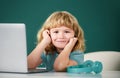 Cute little student boy using laptop computer in school class. Royalty Free Stock Photo