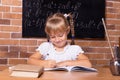 Cute little student girl sitting at a school desk and studying math. The child is doing homework. Preschool education, self Royalty Free Stock Photo