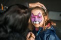 Cute little tiger. Funny girl getting face painting outdoors, having fun, copy space. School time holidays Royalty Free Stock Photo