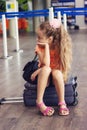 Cute little tired Kid Girl at the Airport, traveling. Sad Child