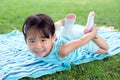 Little toddler girl laying on towel in the grass on a summer day Royalty Free Stock Photo