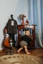 Cute little toddler baby girl in vintage clothes playing at home. Gender-neutral baby fashion. Unisex kid clothes