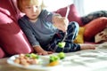 Cute little toddler boy eating broccoli. First solid foods. Fresh organic vegetables for infants Royalty Free Stock Photo