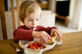Cute little toddler boy eating pancakes and strawberries at home. Fresh organic frutis for infants Royalty Free Stock Photo