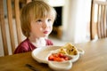 Cute little toddler boy eating pancakes and strawberries at home. Fresh organic frutis for infants Royalty Free Stock Photo