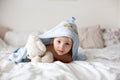 Cute little toddler boy, relaxing in bed after bath, smiling happily, daytime Royalty Free Stock Photo