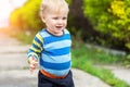 Cute little toddler boy showing mother dirty hands after playing in mud outdoors. Curious child with dirt or soil on palms after Royalty Free Stock Photo