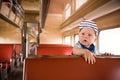 Cute little toddler boy sitting inside the train. Child traveling by railway. young traveler. Vacations. Indoors Royalty Free Stock Photo