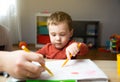 A cute little toddler boy of two years old with dad draws with markers in the album Royalty Free Stock Photo