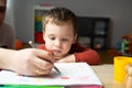 A cute little toddler boy of two years old with dad draws with markers in the album in the children's room at home. Royalty Free Stock Photo