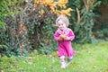 Cute little toddler girl with apple in autumn garden Royalty Free Stock Photo