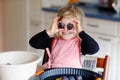 Cute little toddler girl baking plum pie at home. Happy smiling child helping and preparing plums for cake in domestic Royalty Free Stock Photo