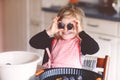 Cute little toddler girl baking plum pie at home. Happy smiling child helping and preparing plums for cake in domestic Royalty Free Stock Photo