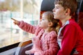 Cute little toddler girl and brother kid boy sitting in train and looking out of window. Two adorable happy healthy Royalty Free Stock Photo