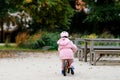 Cute little toddler girl with helmet riding on run balance bike to daycare, playschool or kindergarden. Happy child Royalty Free Stock Photo