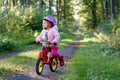 Cute little toddler girl with helmet riding on run balance bike to daycare, playschool or kindergarden. Happy child Royalty Free Stock Photo