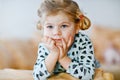 Cute little toddler girl in nightwear pajamas watching cartoons or movie on tv. Happy healthy baby child at home. Royalty Free Stock Photo