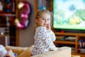 Cute little toddler girl in nightwear pajamas watching cartoons or movie on tv. Happy healthy baby child at home. Royalty Free Stock Photo