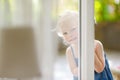 Cute little toddler girl peeking into a window Royalty Free Stock Photo