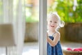 Cute little toddler girl peeking into a window