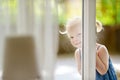 Cute little toddler girl peeking into a window Royalty Free Stock Photo