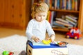 Cute little toddler girl playing at home with eco wooden toys. Happy healthy excited child cutting vegetables and fruits Royalty Free Stock Photo