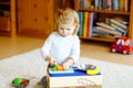 Cute little toddler girl playing at home with eco wooden toys. Happy healthy excited child cutting vegetables and fruits Royalty Free Stock Photo