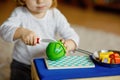 Cute little toddler girl playing at home with eco wooden toys. Happy healthy excited child cutting vegetables and fruits Royalty Free Stock Photo