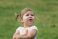 Cute Little toddler girl playing in park in front of green grass Royalty Free Stock Photo