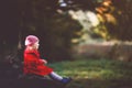 Cute little toddler girl in red coat making a walk through autumn forest. Happy healthy baby enjoying walking with Royalty Free Stock Photo