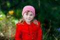 Cute little toddler girl in red coat making a walk through autumn forest. Happy healthy baby enjoying walking with Royalty Free Stock Photo