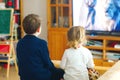 Cute little toddler girl and school kid boy watching animal movie or movie on tv. Happy healthy children, siblings Royalty Free Stock Photo