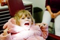 Cute little toddler girl sitting with open mounth at the dentist. Happy brave child waiting for treatment. Teeth hygiene