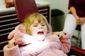 Cute little toddler girl sitting with open mounth at the dentist. Happy brave child waiting for treatment. Teeth hygiene
