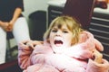 Cute little toddler girl sitting with open mounth at the dentist. Happy brave child waiting for treatment. Teeth hygiene