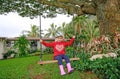 Cute little upset girl swinging on wooden swing outdoors Royalty Free Stock Photo