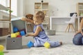 Cute Little 2 Year Old Child Putting Toys Back In Their Place, Helping Mommy To Tidy Up