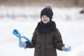 Cute little young funny toothless child boy in warm clothing playing having fun making snowballs on winter cold day on white brigh Royalty Free Stock Photo